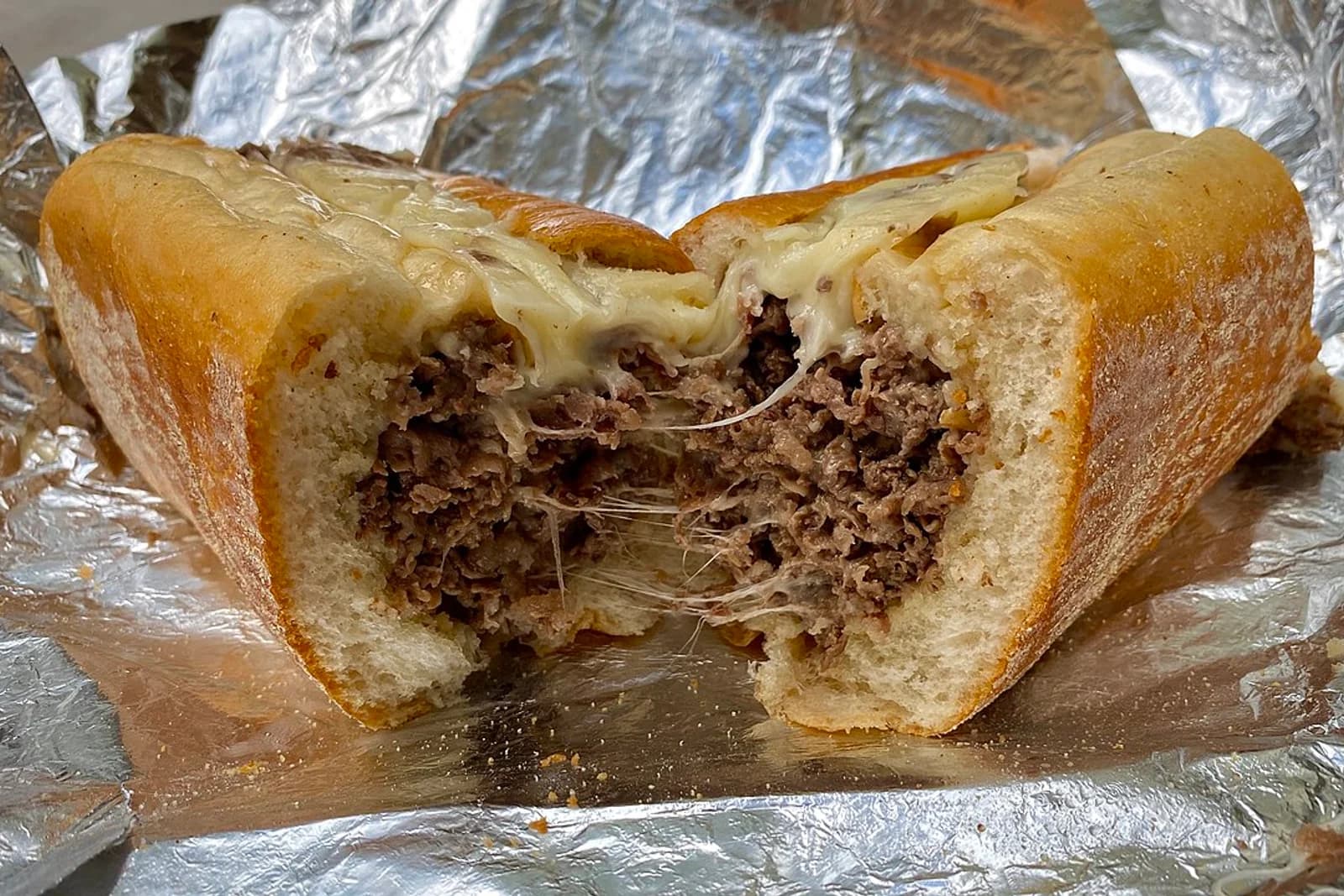 A chopped-beef Philadelphia cheesesteak with melted cheese on a seeded long roll